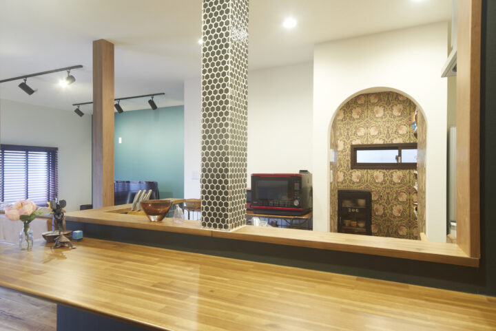 構造上抜けない柱はデザインとして活かし、S様自らタイルで装飾。 Rの下がり壁の奥はパントリーになっている。